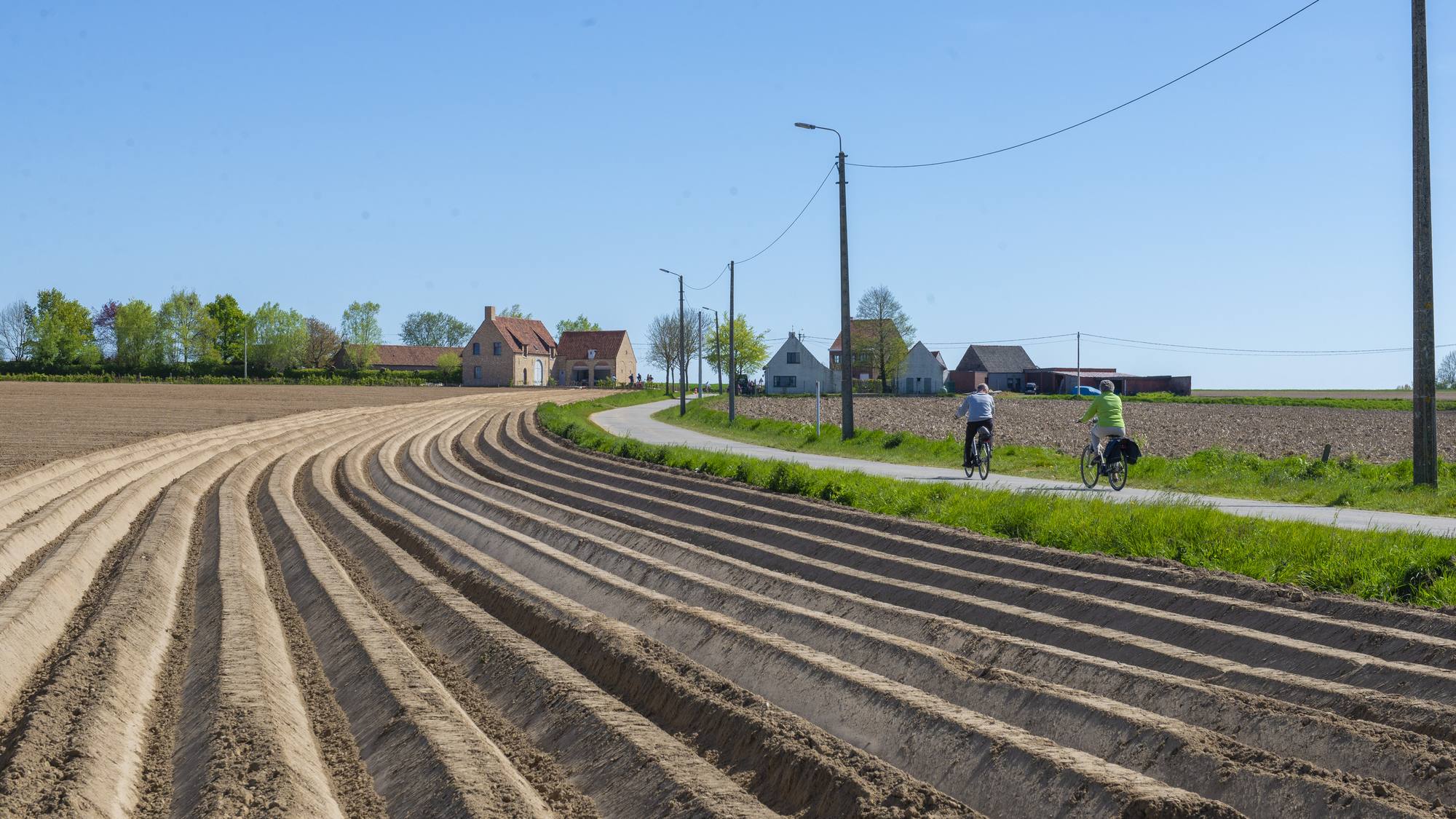 Velden en fietsers aan de rand van Huise